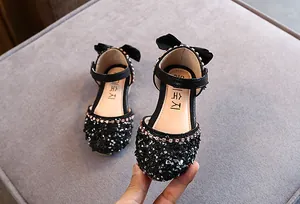 Gedetailleerd overzicht van zwarte prinsessensandalen voor meisjes met elegante strass en strikken