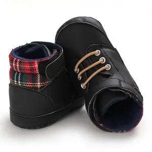 Close-up of black high-top baby walking shoes featuring stylish red plaid collar details