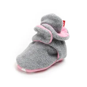 Detail of grey and pink fleece baby winter booties with warm lining and soft sole