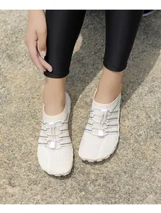 Primer plano de zapatos de agua beige de secado rápido con cordones elásticos en el suelo