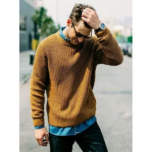 Detailed view of men's mustard yellow ribbed knit sweater styled in an urban setting
