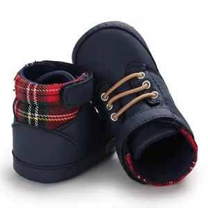 Detail view of navy blue baby high-top walking shoes with plaid trim and soft soles