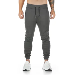 Front view of men's dark grey slim fit joggers on a muscular model for fitness training