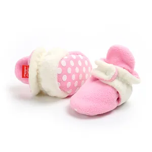Soft fleece pink baby booties featuring white polka dot soles and Velcro straps for winter
