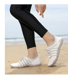 Zapatos de agua blancos de secado rápido en la arena para el verano