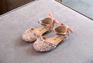 Detailopname van roze prinsessenschoenen voor meisjes met strassteentjes en strik
