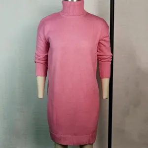 Detailweergave van een gezellige roze gebreide trui-jurk met kol en lange mouwen.