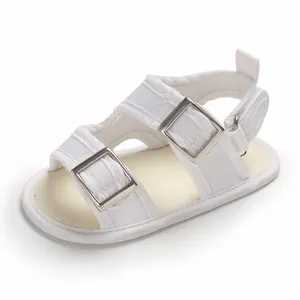 Dettaglio di sandalo bianco per neonati con fibbie in metallo e suola antiscivolo