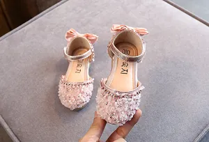 Detailoverzicht van roze prinsessensandalen voor meisjes met stras en bloemblaadjes.