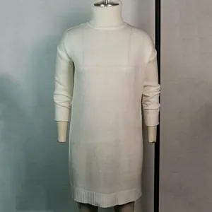 Detailopname van een witte gebreide jurk met col en lange mouwen voor herfst en winter