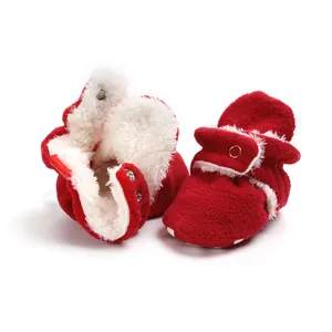Detail view of red winter baby booties with soft white fleece lining and warm texture.