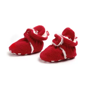 Detailed close-up view of red plush winter baby booties with soft soles for walkers
