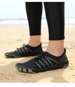 Vista detallada de calzado acuático negro de secado rápido para hombre y mujer en la playa
