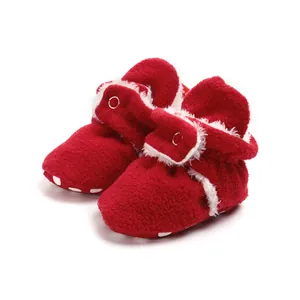 Detail view of red winter baby plush booties with soft trim and non-slip soles