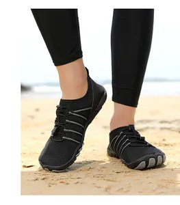 Primer plano de zapatos de agua negros de secado rápido con suelas de goma antideslizantes en playa