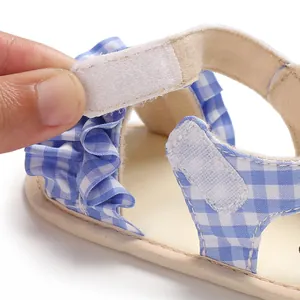 Dettaglio macro di sandali neonato a quadretti blu con chiusura a strappo in velcro