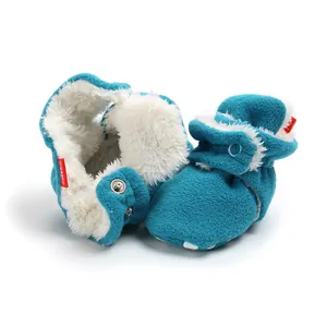 Close-up of blue winter baby booties with soft white sherpa lining and snap closure