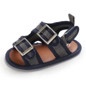 Dettaglio di sandali blu scuro per neonati con fibbie in metallo e suola morbida.