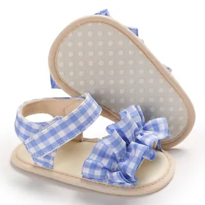 Dettaglio sandali neonato a quadretti blu con volant e suola beige morbida antiscivolo