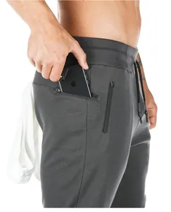Close-up detail of grey athletic joggers showing the functional side zipper pocket design