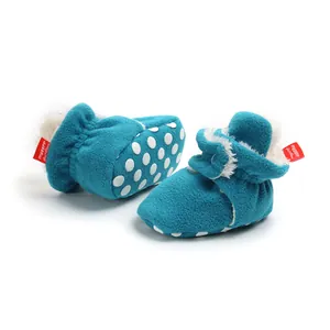 Detailed view of warm blue fleece infant booties with non-slip polka dot soles