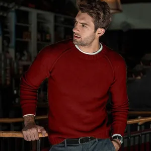 Lifestyle shot of a man wearing a classic burgundy crew neck long sleeve knit sweater