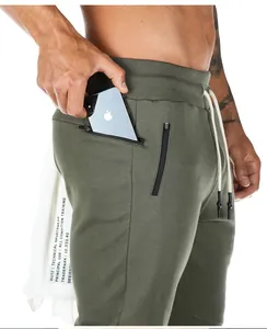 Close-up detail of olive green men's athletic joggers featuring a functional zipper pocket