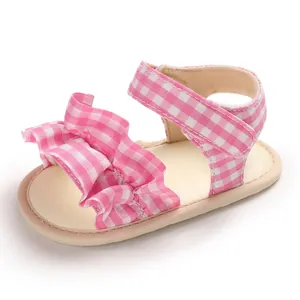 Primo piano di sandali neonata a quadretti rosa con dettagli in rouches