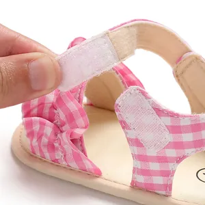 Primo piano del sandalo per neonati a scacchi rosa con cinturino in velcro regolabile