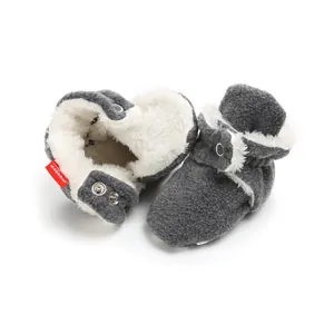 Detail view of plush-lined baby winter booties with soft fleece fabric and snap buttons.