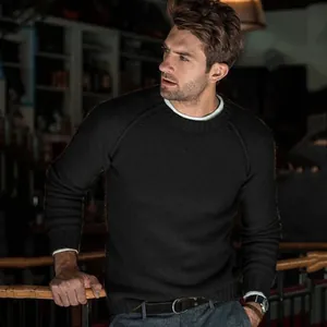 Close-up detail shot of a men's classic black crewneck sweater with fine knit texture.
