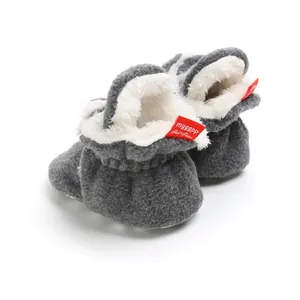 Close-up view of grey fleece baby winter booties with a soft white fuzzy lining