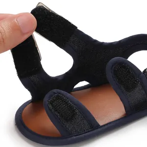 Dettaglio del cinturino in velcro regolabile sui sandali da bambino di colore blu scuro