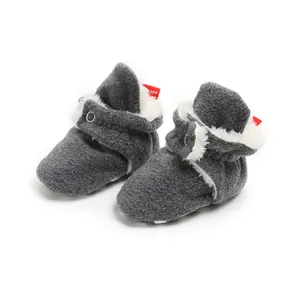 Close-up of grey baby winter booties with soft fleece lining and snap button