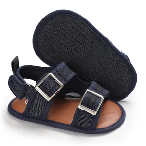 Dettaglio ravvicinato di sandali blu navy per neonati con suola antiscivolo e fibbie