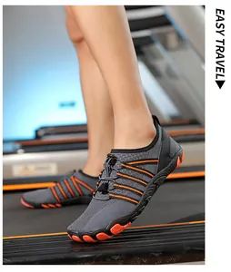Detalle de zapatos de agua grises de secado rápido con suela naranja en una cinta de correr