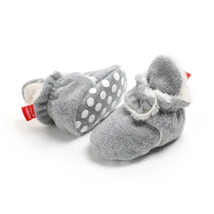 Detail view of plush grey baby winter booties featuring soft anti-slip polka dot soles
