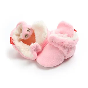 Detail of soft pink fleece baby winter booties with thick warm lining and snap closures.