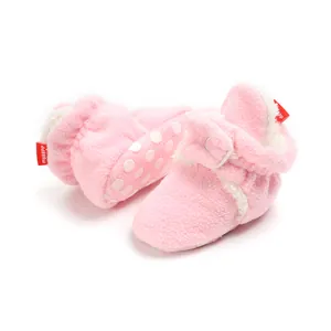 Detailed view of pink fuzzy baby winter booties featuring soft anti-slip polka dot soles