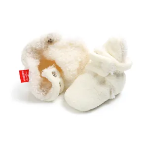 Detail of plush cream baby winter booties featuring snap button closure and soft fleece.