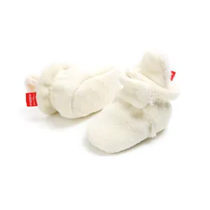 Close-up detail view of cozy cream fleece baby booties with non-slip soft soles