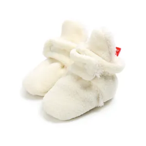Macro detail view of soft cream white fleece winter baby booties with velcro strap