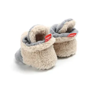 Close-up view of soft grey and beige fleece baby booties featuring a warm lining