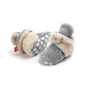 Close-up of baby winter booties with soft gray fleece and white polka dots