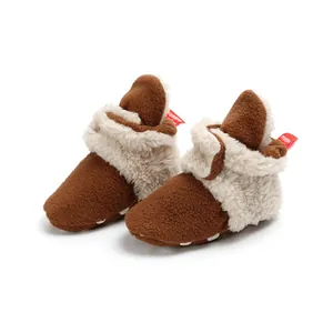 Detail of plush brown infant winter boots with soft faux fur lining and red tag.