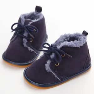 Detailansicht von Winter-Babystiefeln mit weichem Plüschfutter und marineblauen Schnürsenkeln.
