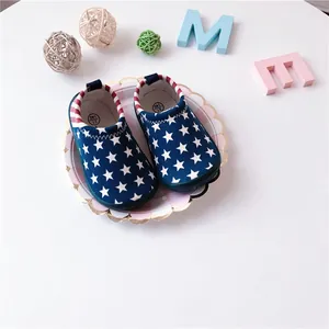 Detail of toddler canvas slip-on shoes with stars and stripes pattern on white plate.
