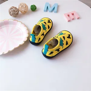 Yellow children's canvas slip-on walking shoes with dinosaur silhouette patterns