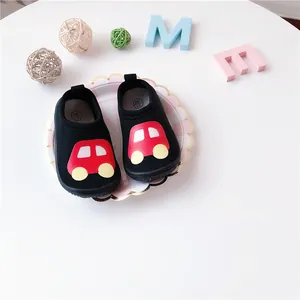 Detailed macro shot of black toddler walking shoes featuring a red cartoon car design