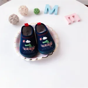 Close-up of navy blue baby slip-on canvas shoes with cute crocodile pattern